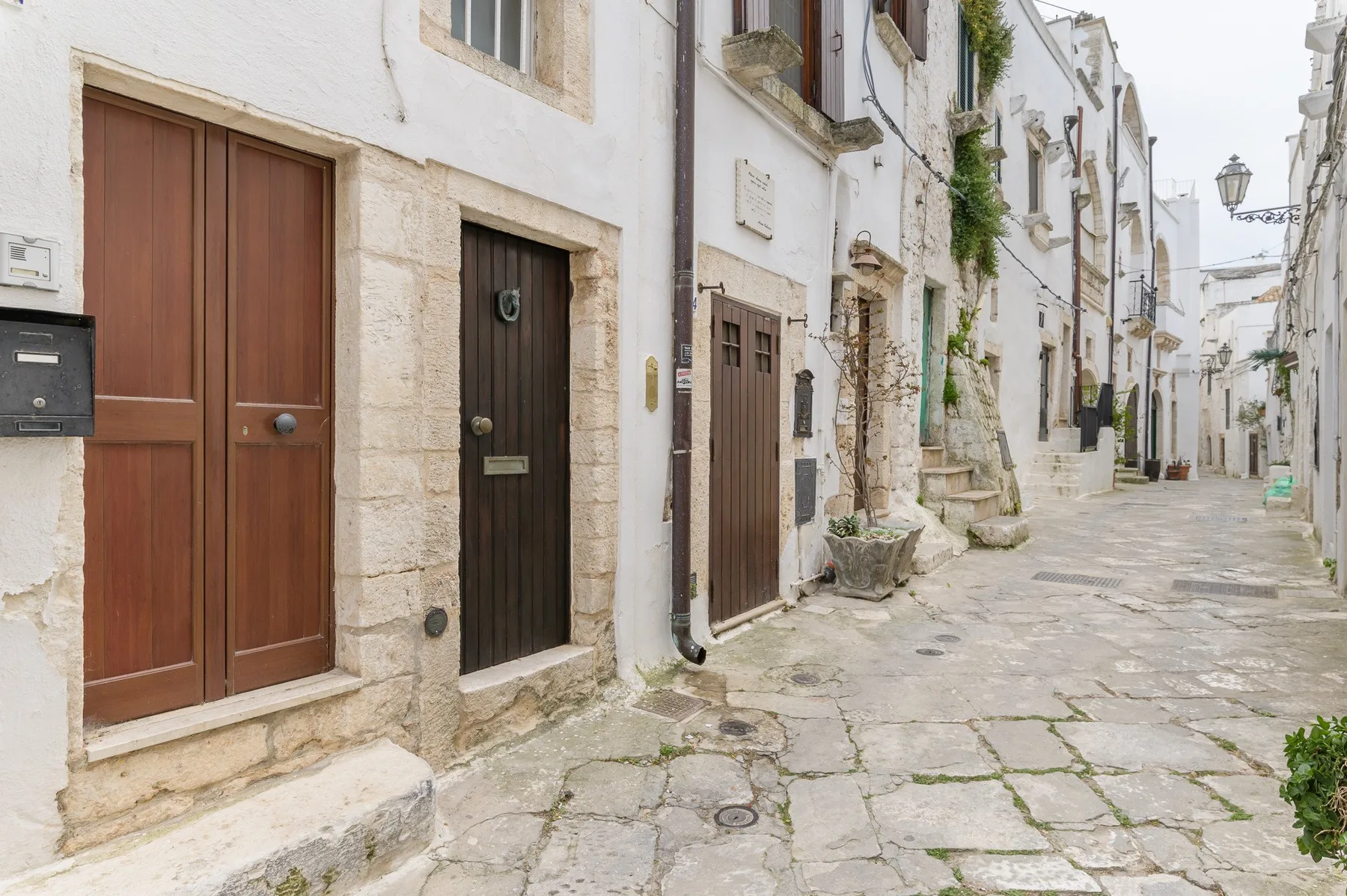 Una calle estrecha pavimentada con piedra pasa entre edificios muy próximos.