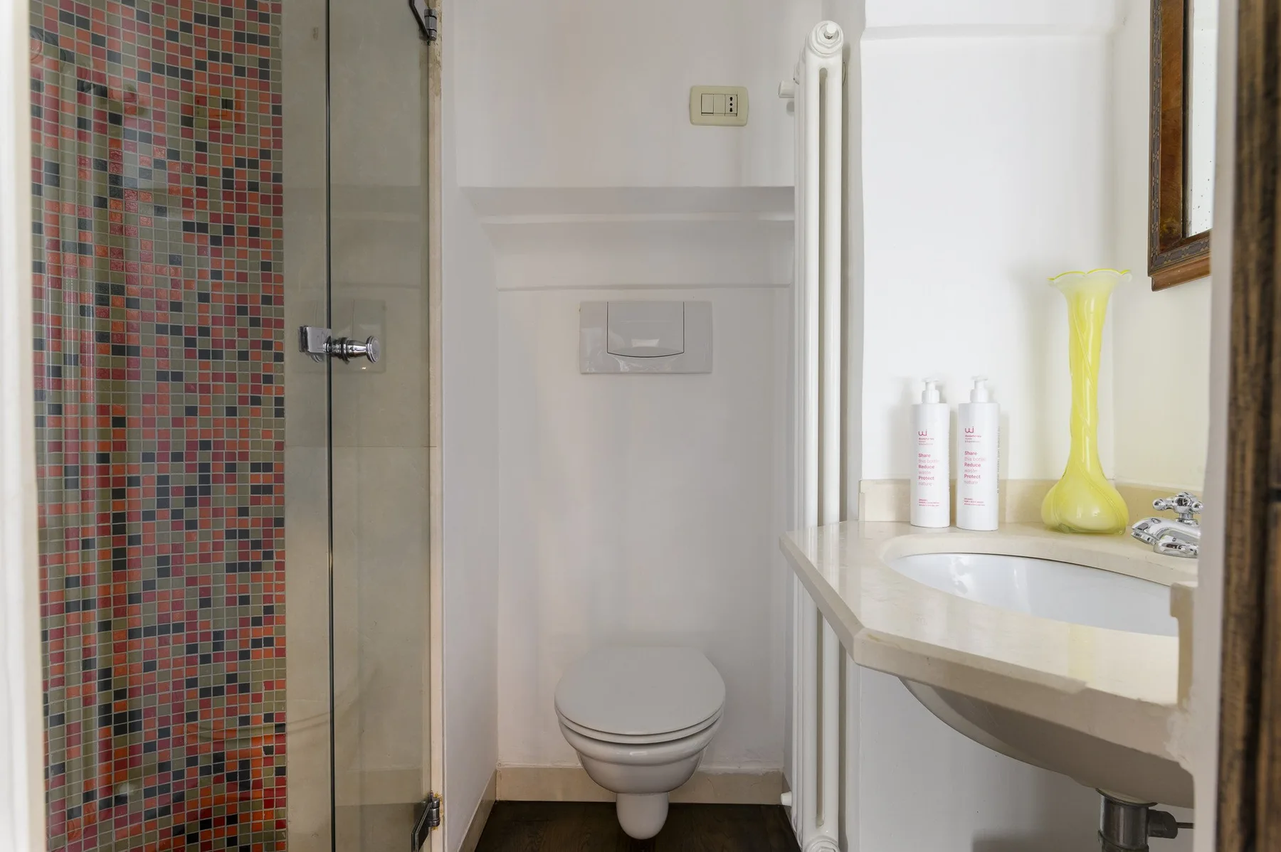 Un baño con ducha de vidrio, inodoro y lavabo.