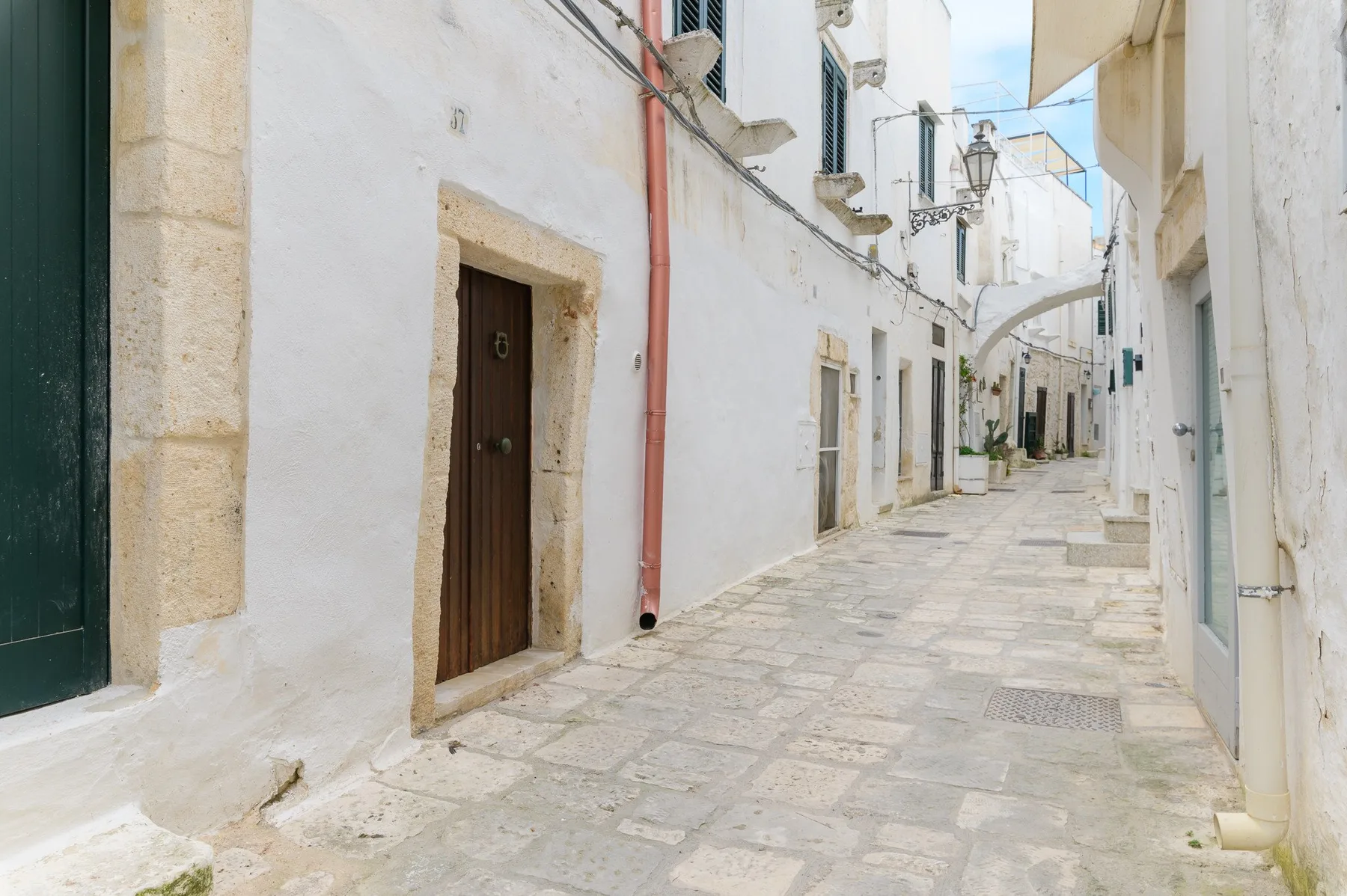 Una calle estrecha empedrada pasa entre edificios encalados.
