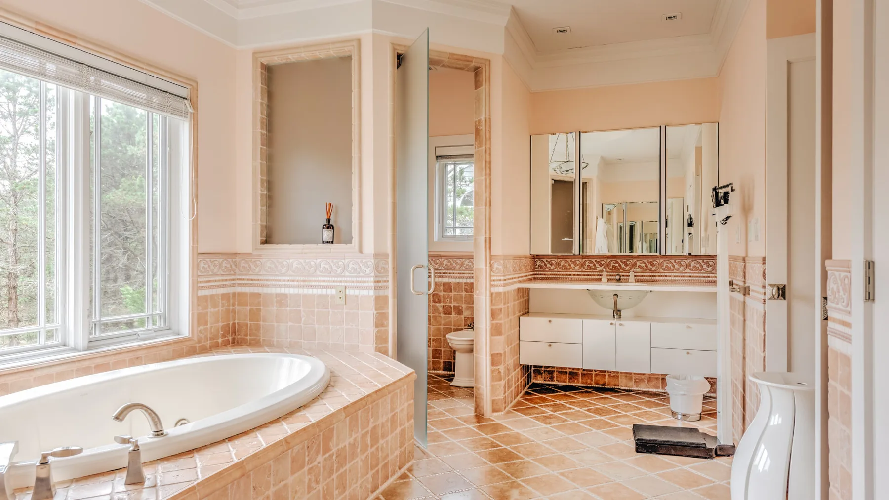 A bathroom with a bathtub, a sink vanity, and tiled surfaces.