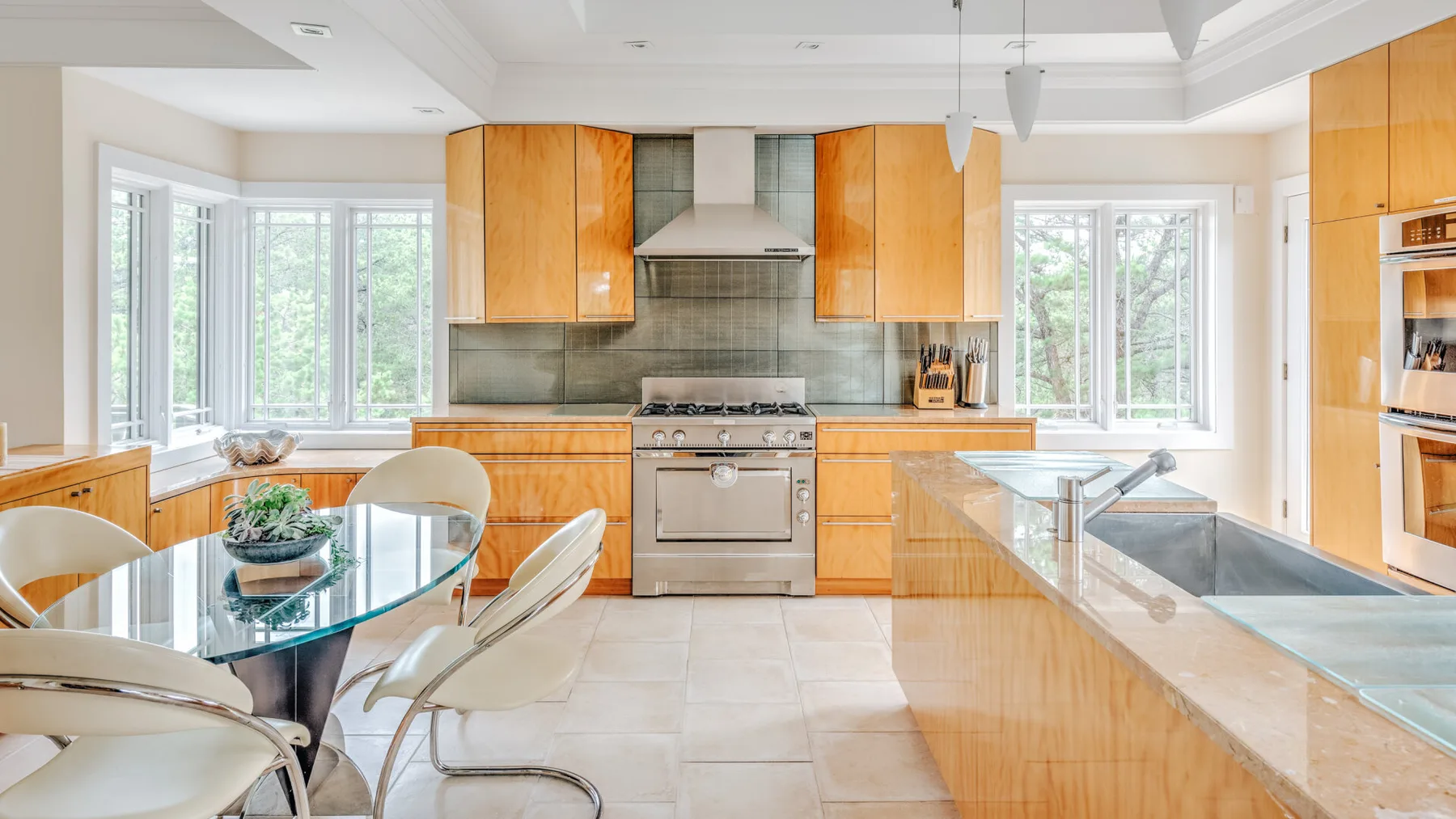 A bright kitchen with wood cabinetry, a central cooking area, and an island.