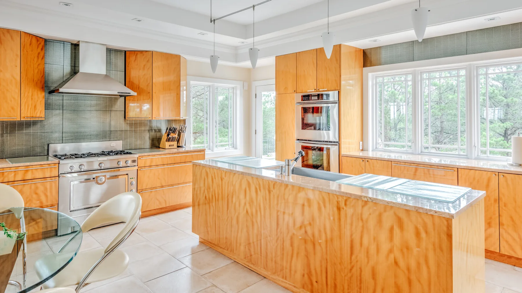 A bright kitchen with wooden cabinetry, stainless steel appliances, and a central island.