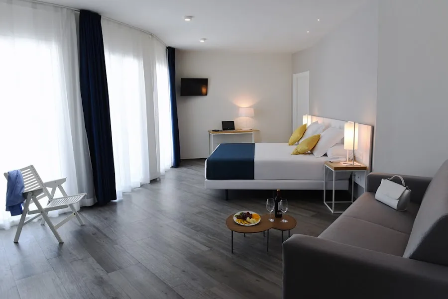 Hotel room with bed and sofa.