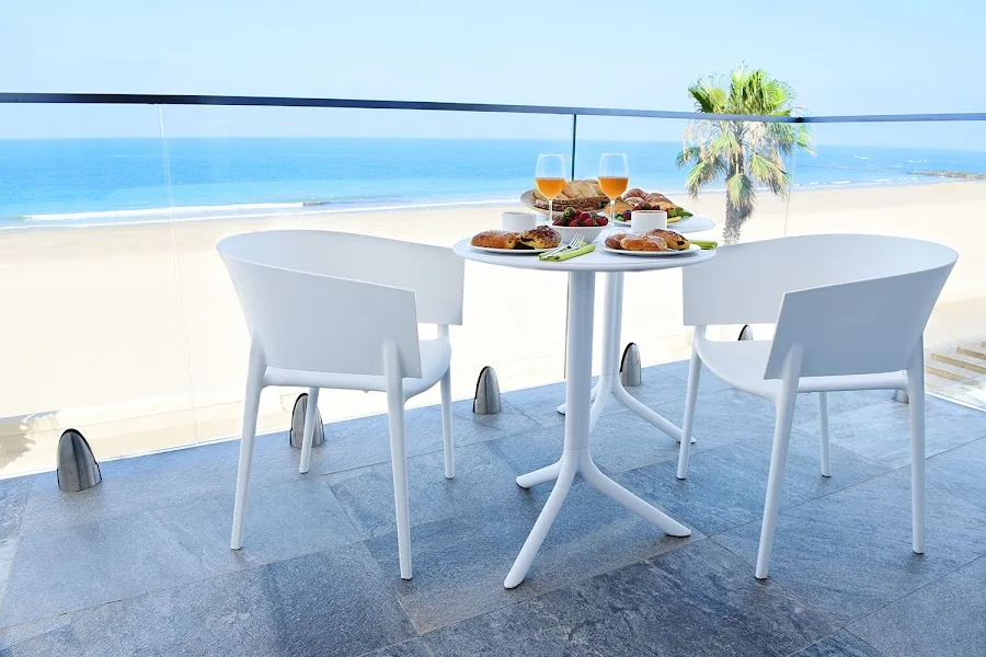 Breakfast on a hotel balcony overlooking the sea.