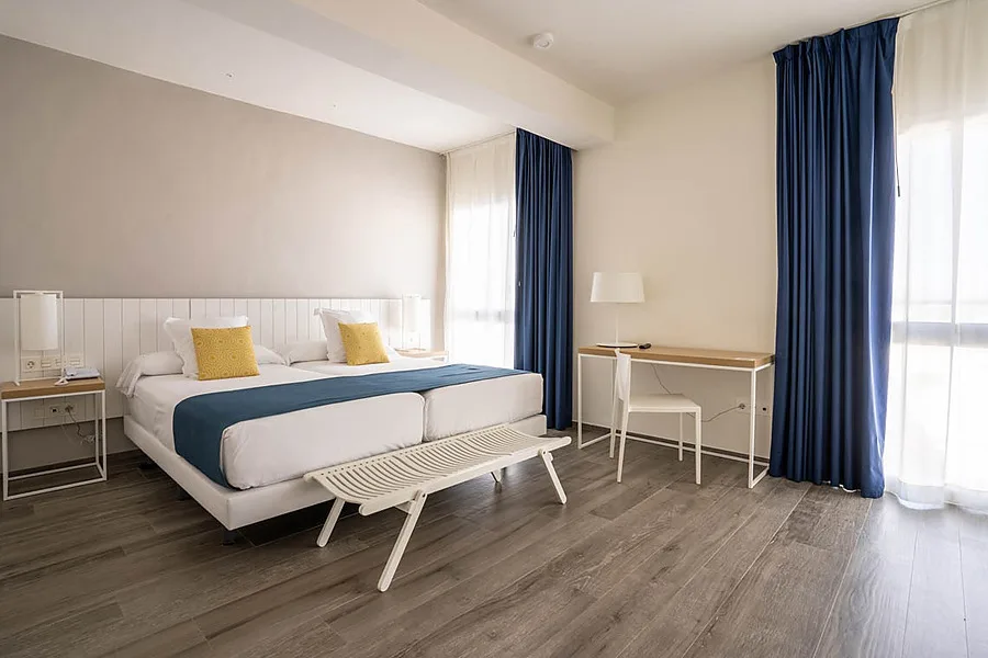 Hotel room with twin beds and desk.