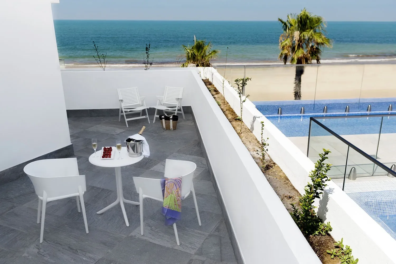 Hotel terrace with views of the sea and pool.