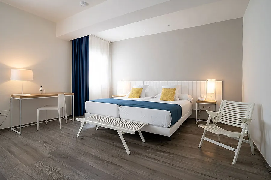 Hotel room with twin beds and desk.