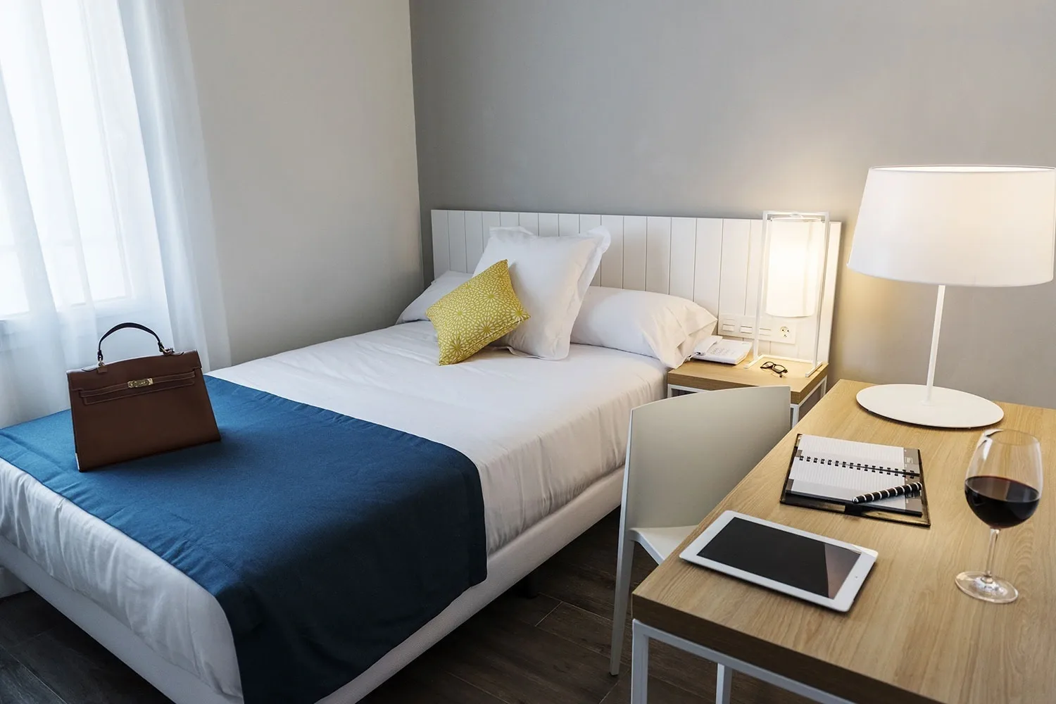 Hotel room with a bed and desk.