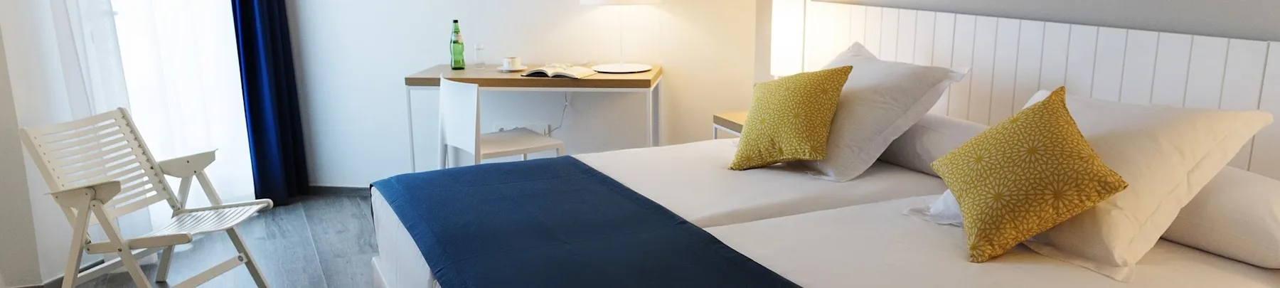 Hotel room with twin beds and desk.