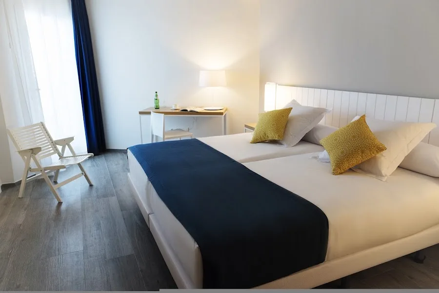Hotel room with twin beds and desk.