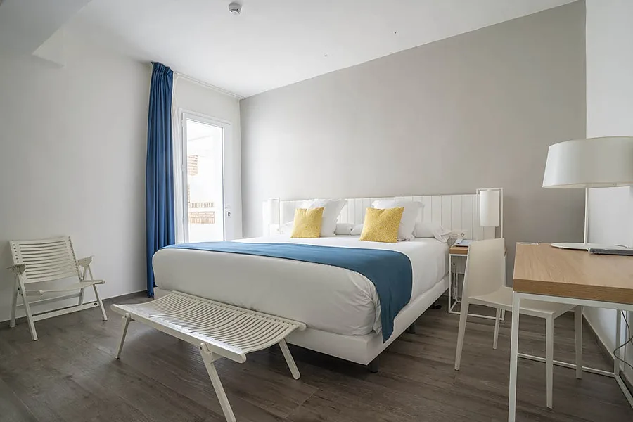 Hotel room with double bed and balcony.