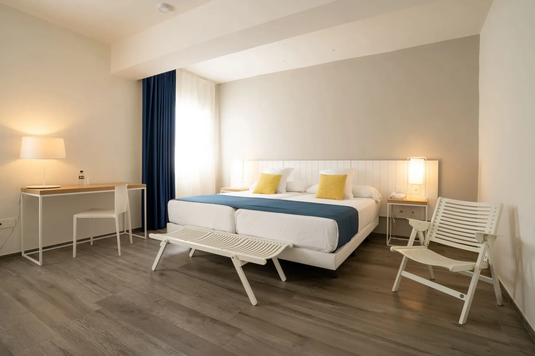 Hotel room with twin beds and a desk.
