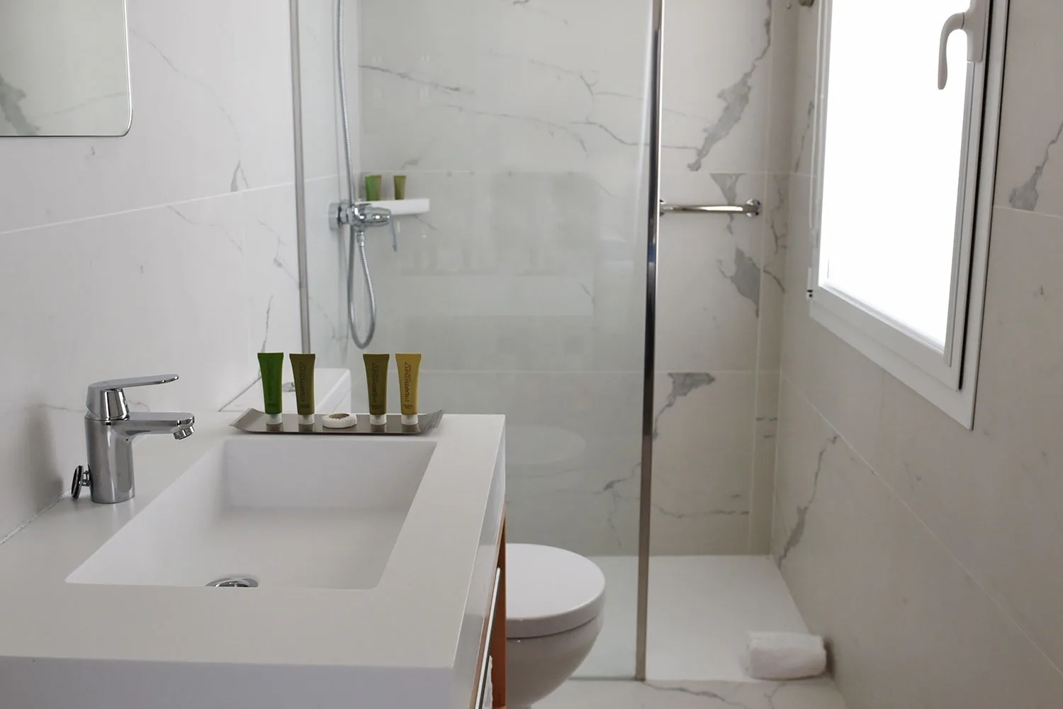 Hotel bathroom with shower and sink.