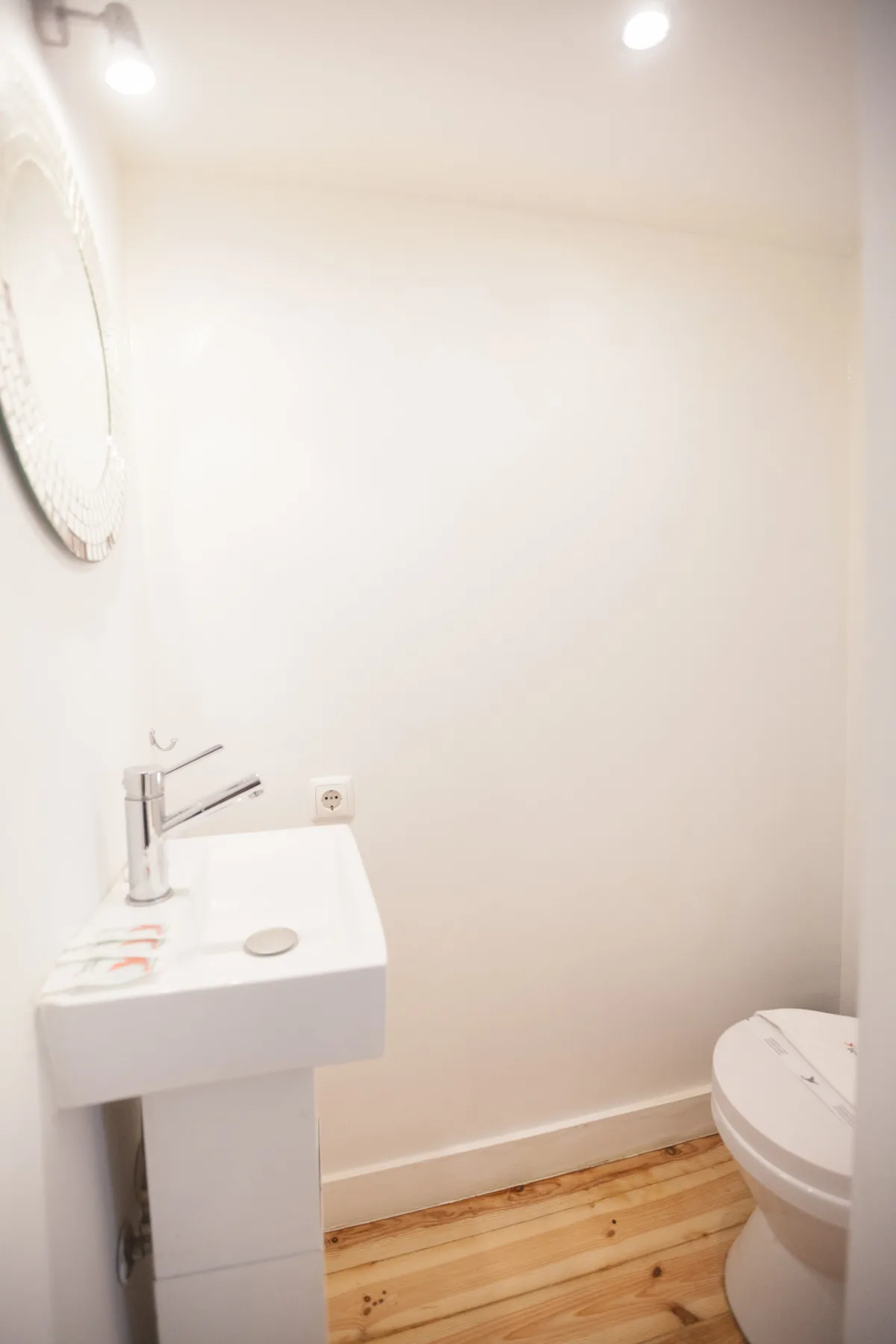 Un baño pequeño con lavabo de pedestal e inodoro.