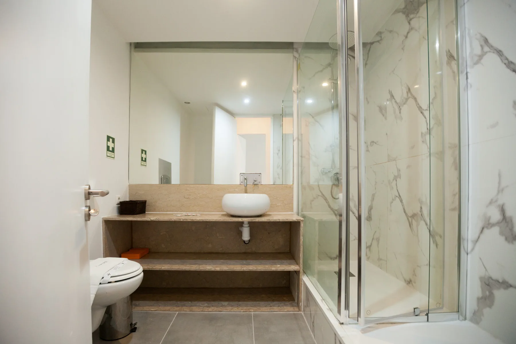 Un baño moderno con lavabo, inodoro y ducha de cristal.