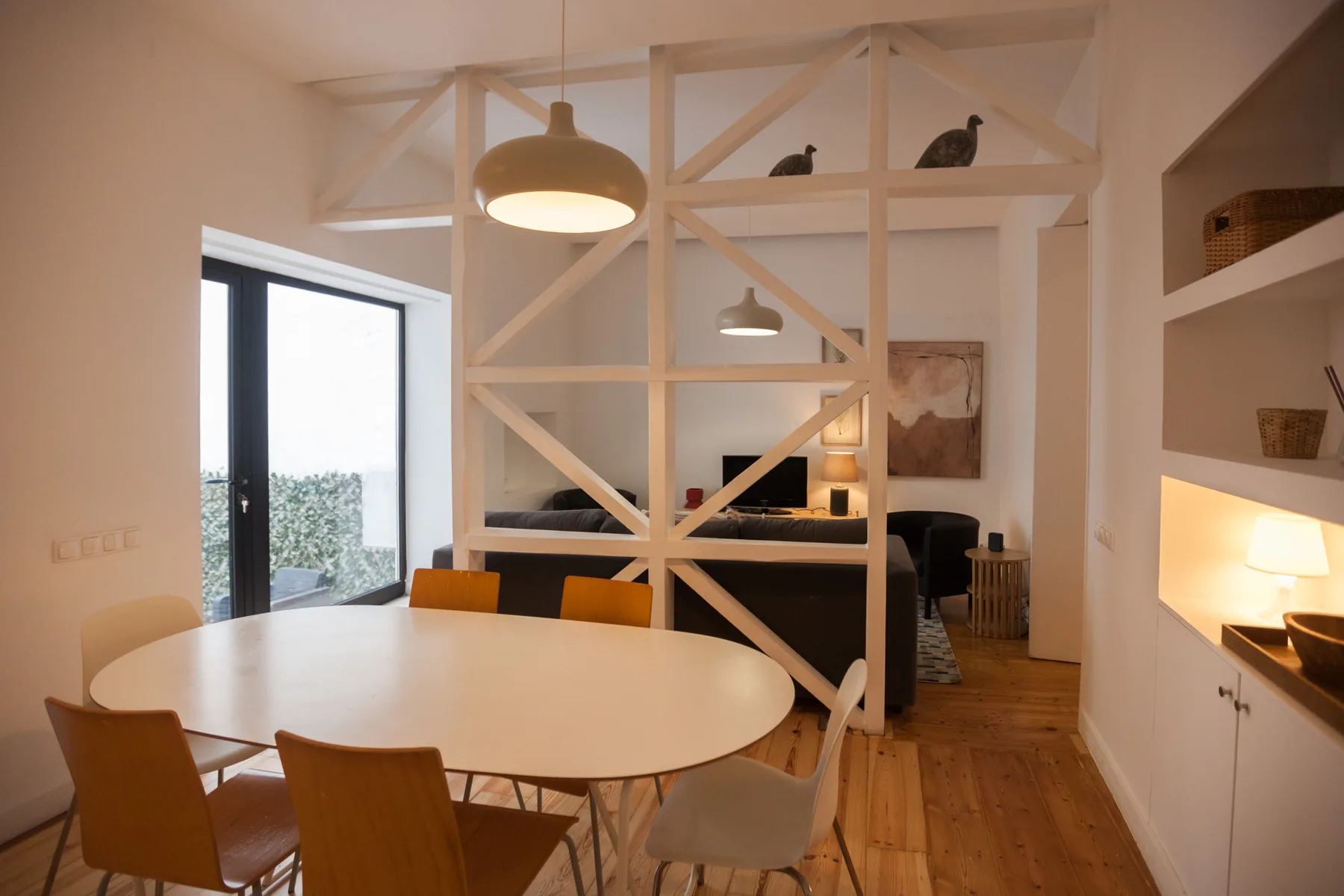 Un comedor con una mesa ovalada junto a una sala de estar abierta.