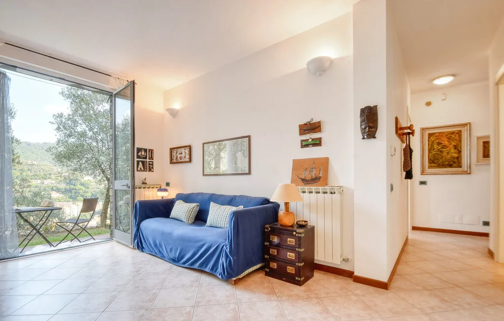 Una sala luminosa con asientos azules junto a puertas de vidrio abiertas.