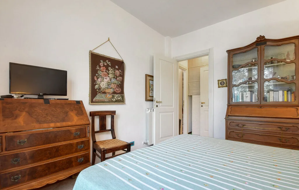 Un dormitorio con una cama, muebles de madera y un televisor.