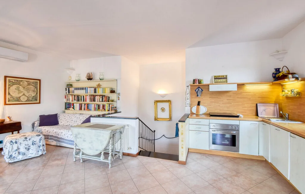 Una luminosa sala de estar y cocina de concepto abierto, con mesa de comedor y estanterías.