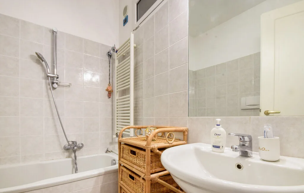 Un baño con azulejos, bañera, ducha y lavabo.