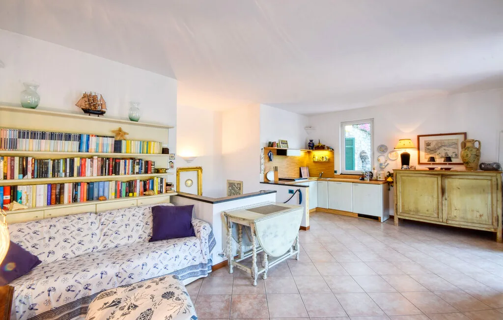 Una sala luminosa con estanterías llenas de libros, asientos y suelo de baldosas.