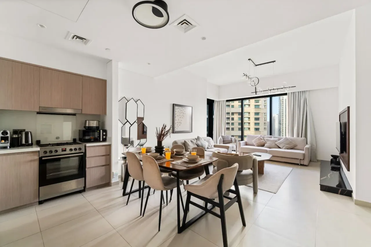 Una sala-comedor de concepto abierto con cocina y ventanas grandes.