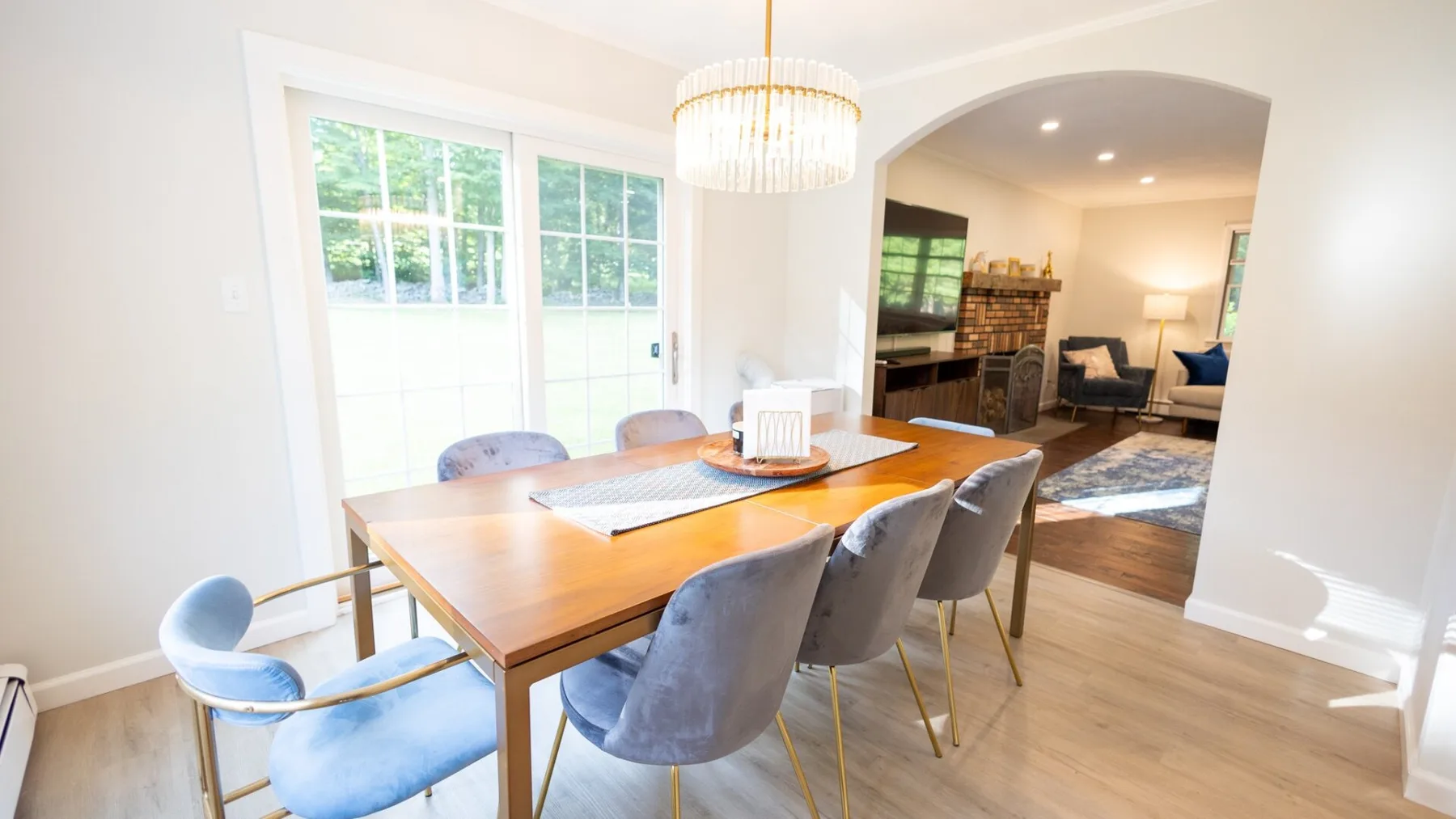 A dining area with a wooden table and chairs beside a bright window.