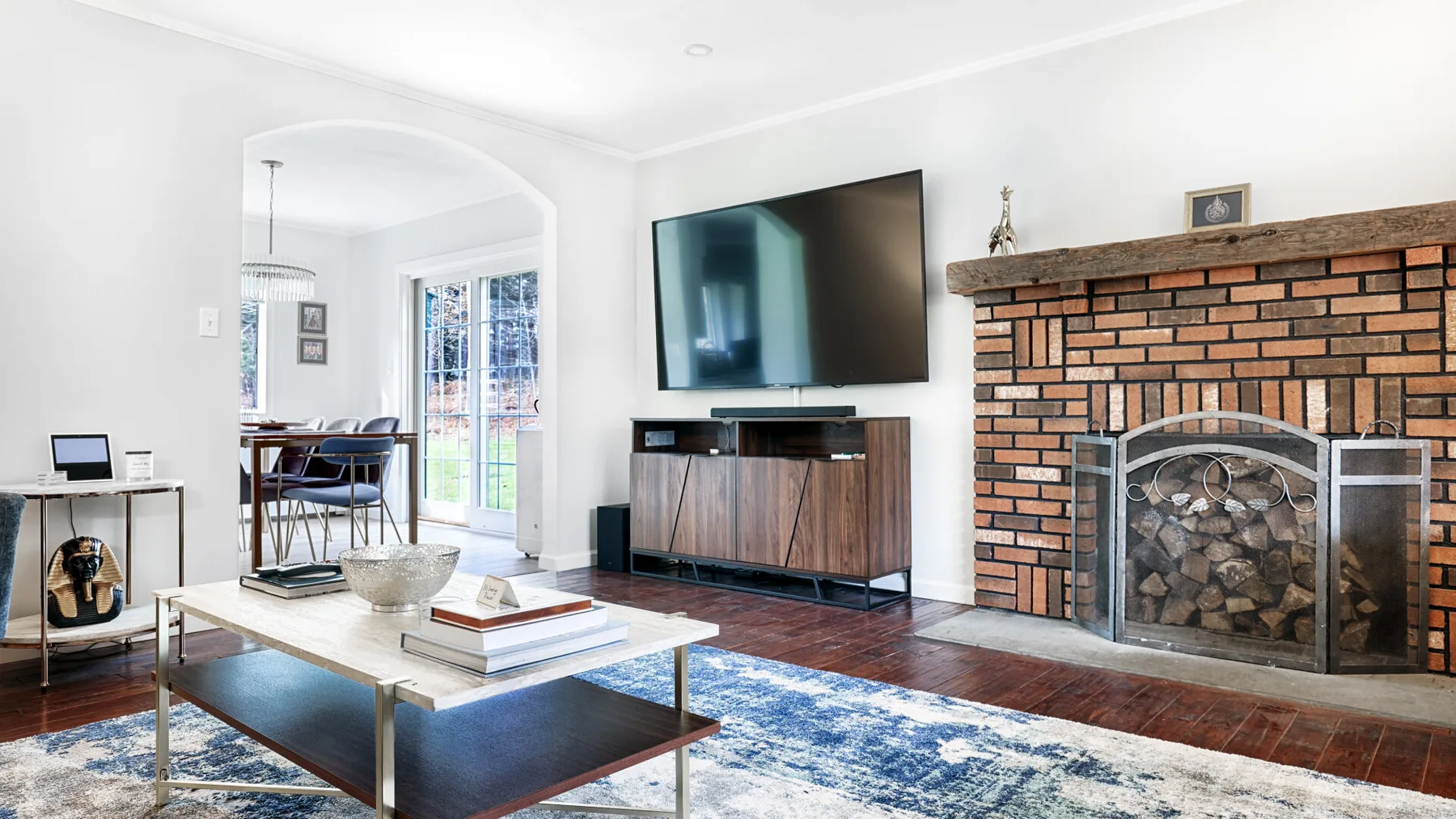 A living room with a television, brick fireplace, and seating area.