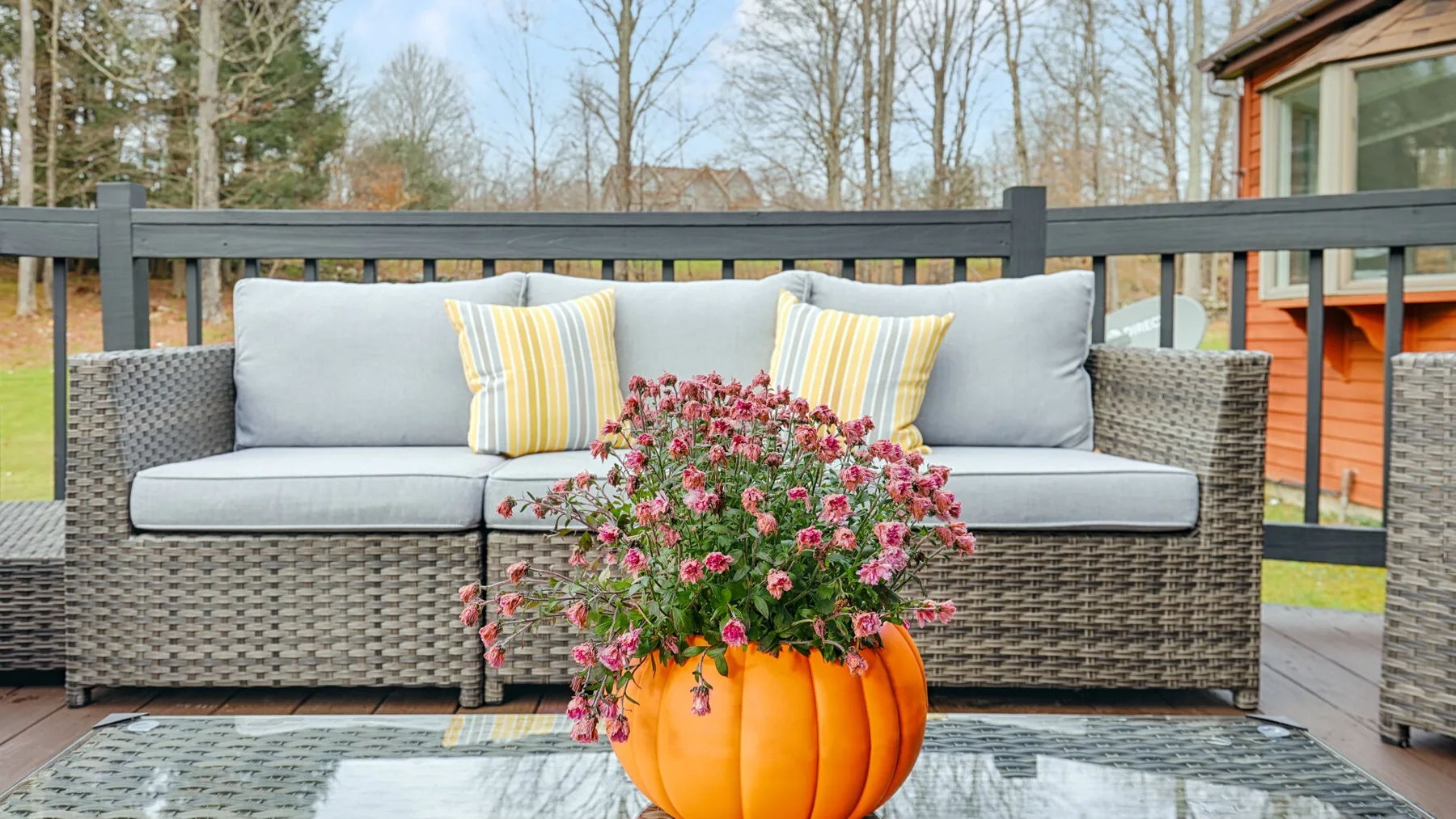 Outdoor seating on a deck with striped cushions and a flowering plant.