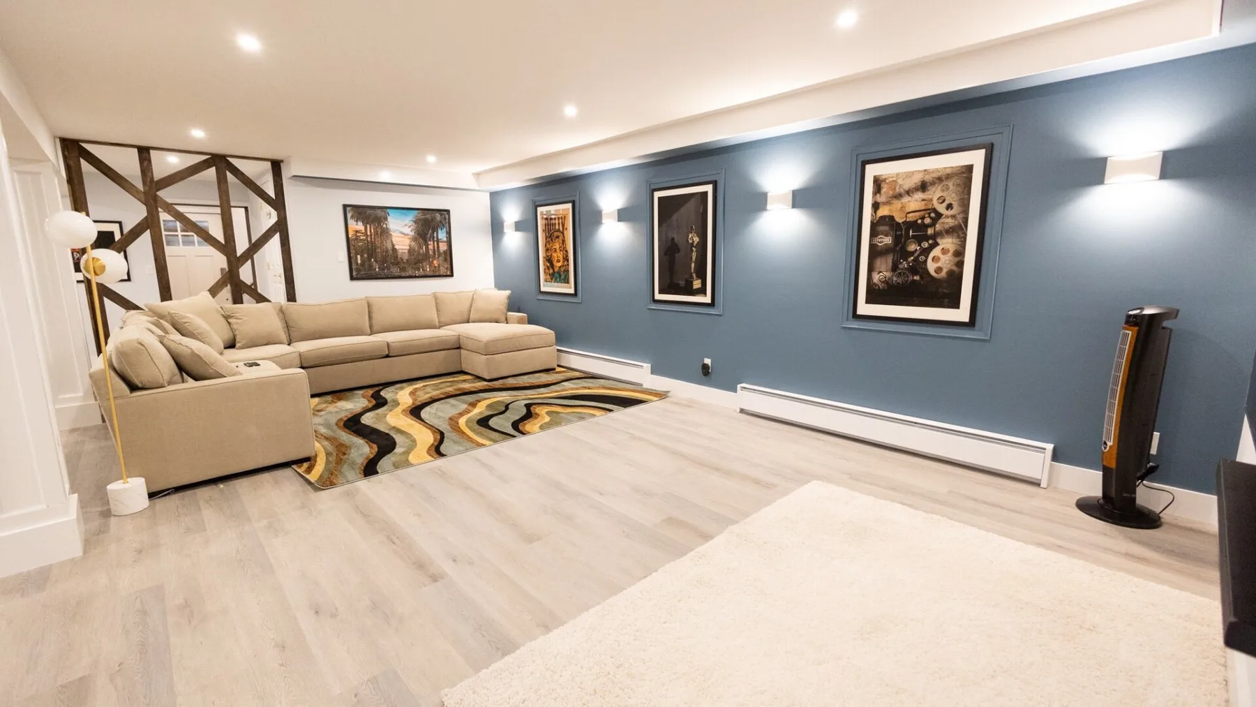 A living room with seating, framed artwork, and a patterned rug.