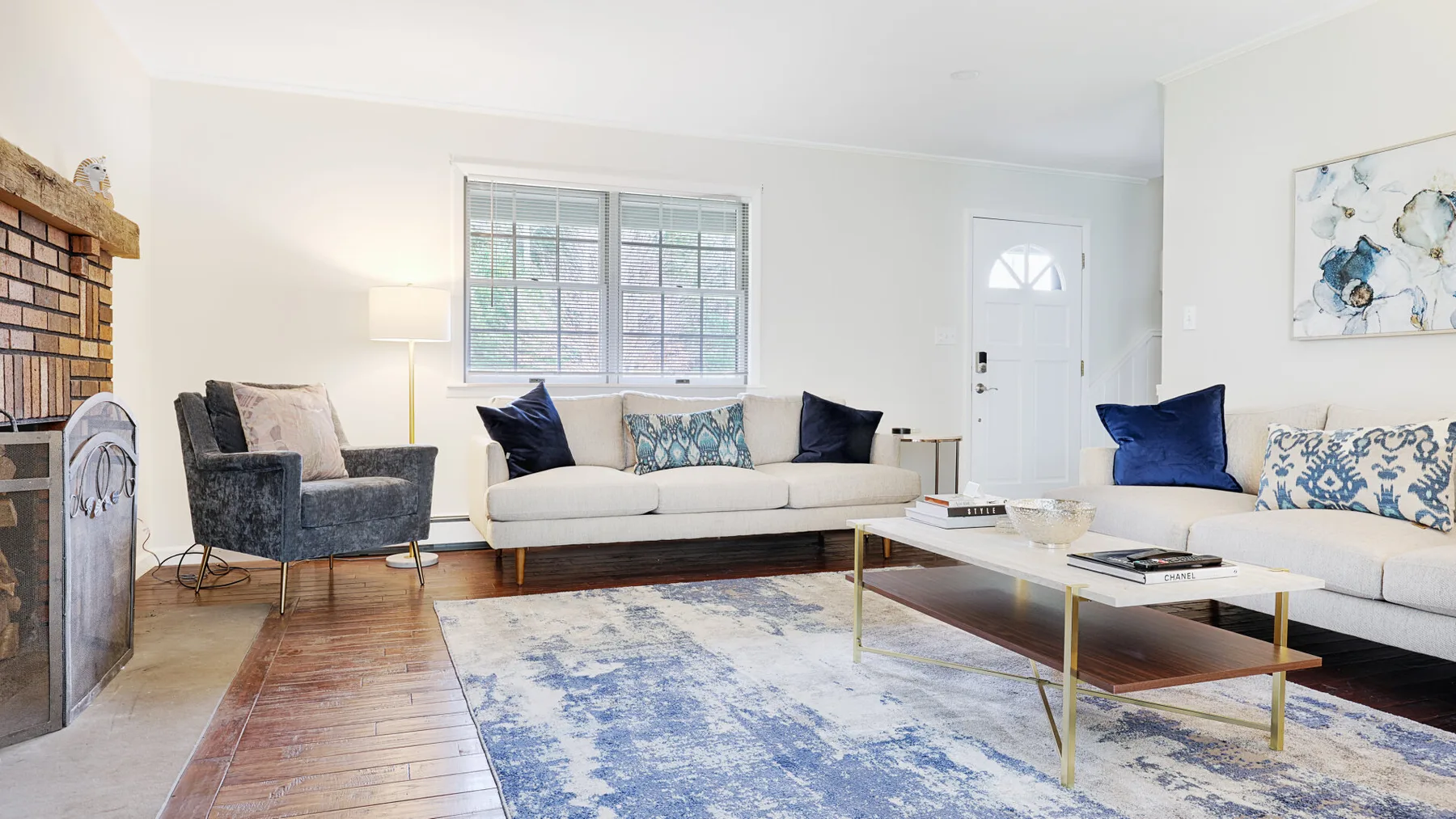 A bright living room with seating around a coffee table and a large rug.