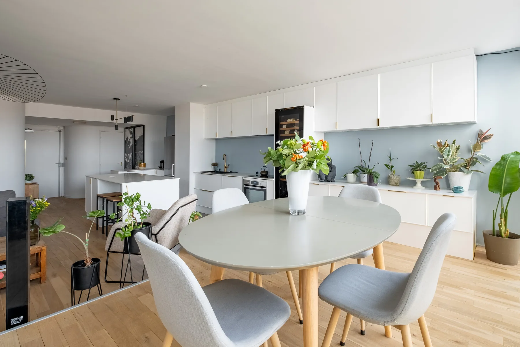 A bright kitchen and dining area with a table, chairs, and plants.