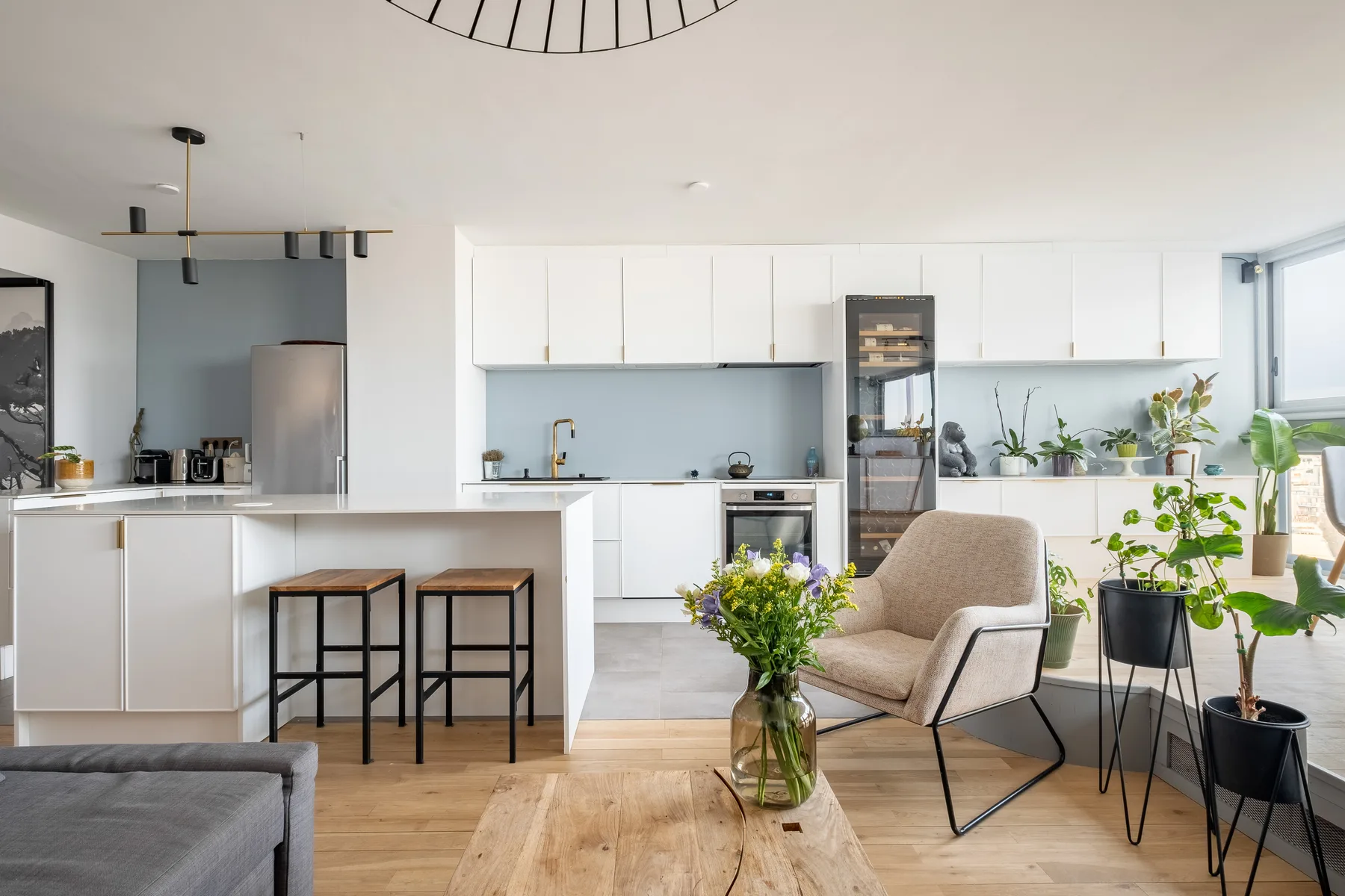 Una luminosa cocina abierta al salón, con barra para comer y asientos.