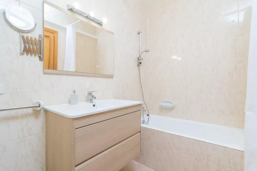 A bright bathroom with a sink, vanity, and bathtub.