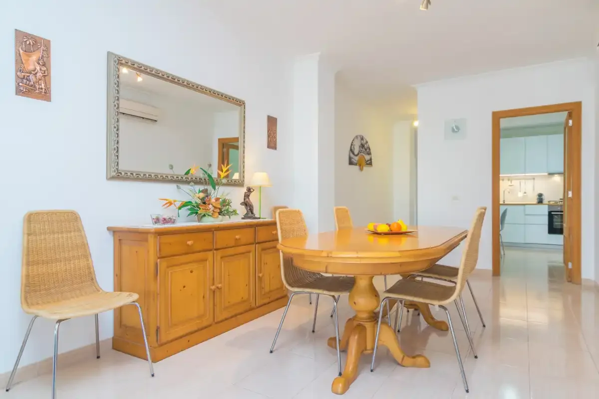 A dining area with a wooden table and chairs beside a sideboard.