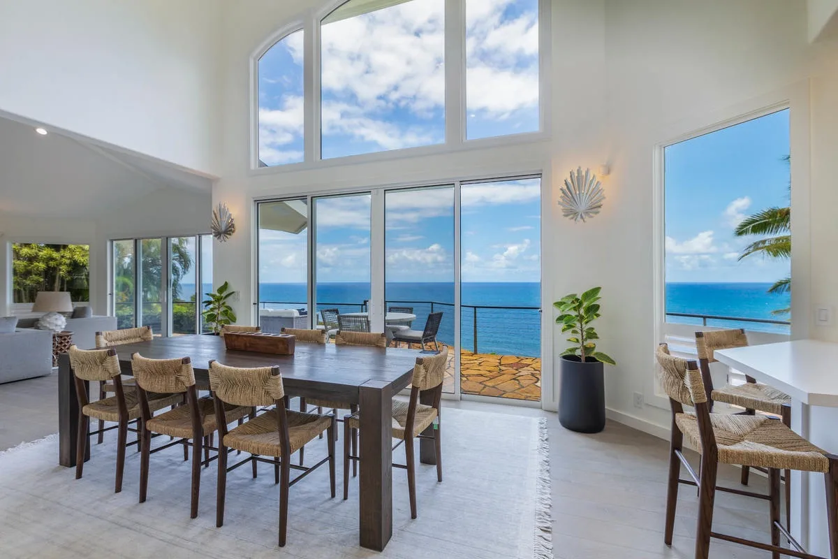 Un comedor luminoso con grandes ventanales con vistas al océano.