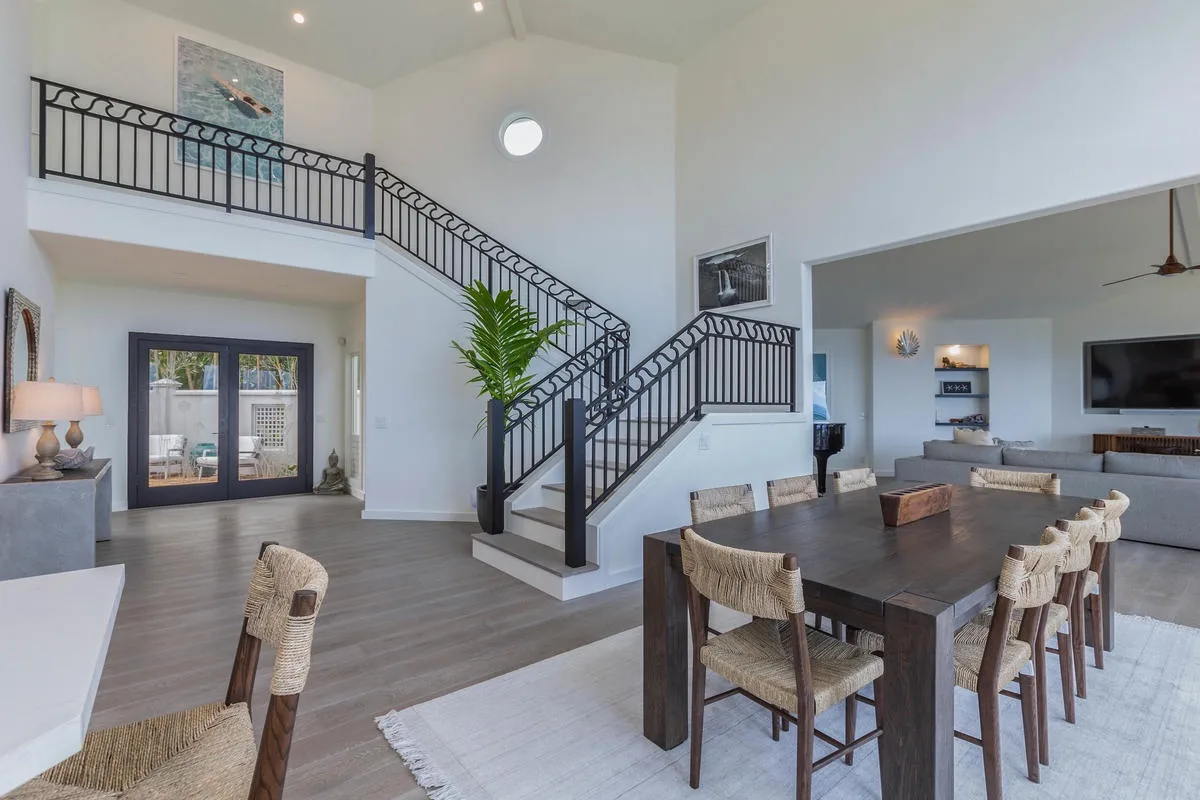 An open living and dining area with a staircase and a long dining table.