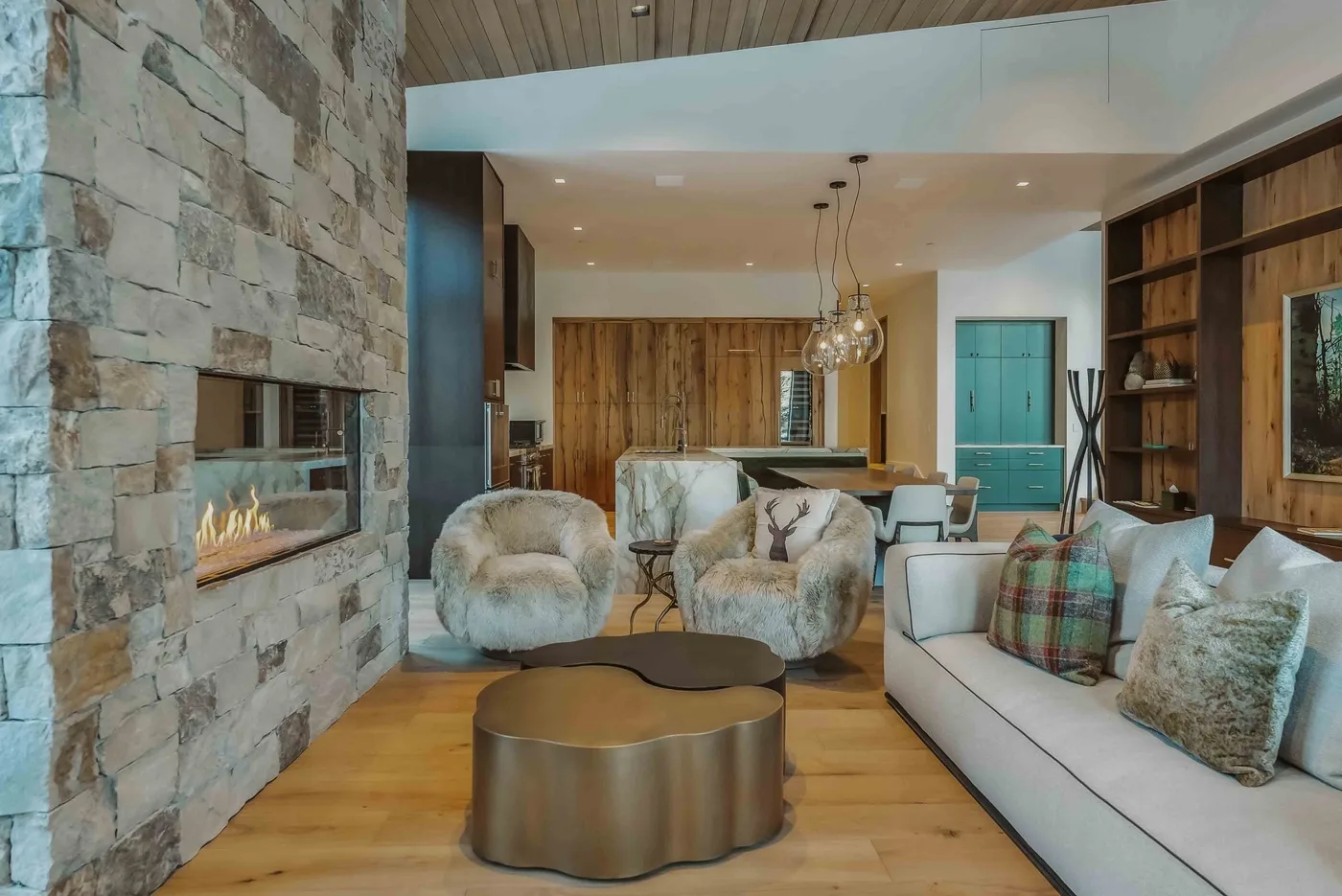 Una sala de estar con chimenea de piedra y asientos alrededor de una mesa de centro baja.