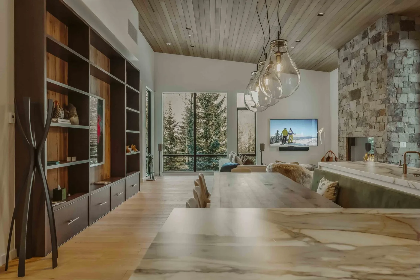 Una sala-comedor de planta abierta con una mesa larga y grandes ventanales.