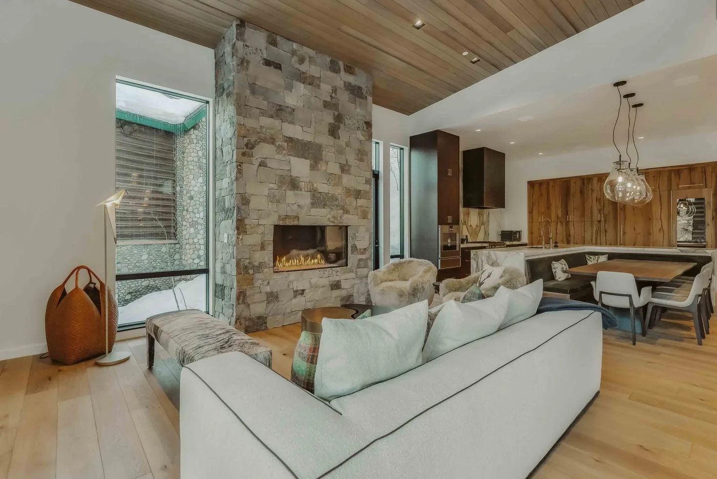 Una sala de estar de planta abierta con chimenea de piedra y comedor.
