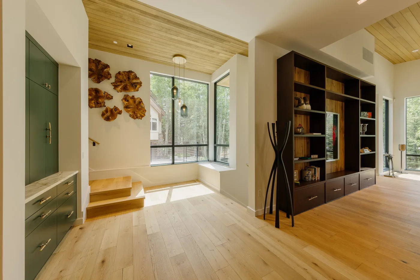 Una sala de estar luminosa con una ventana grande y estanterías empotradas.