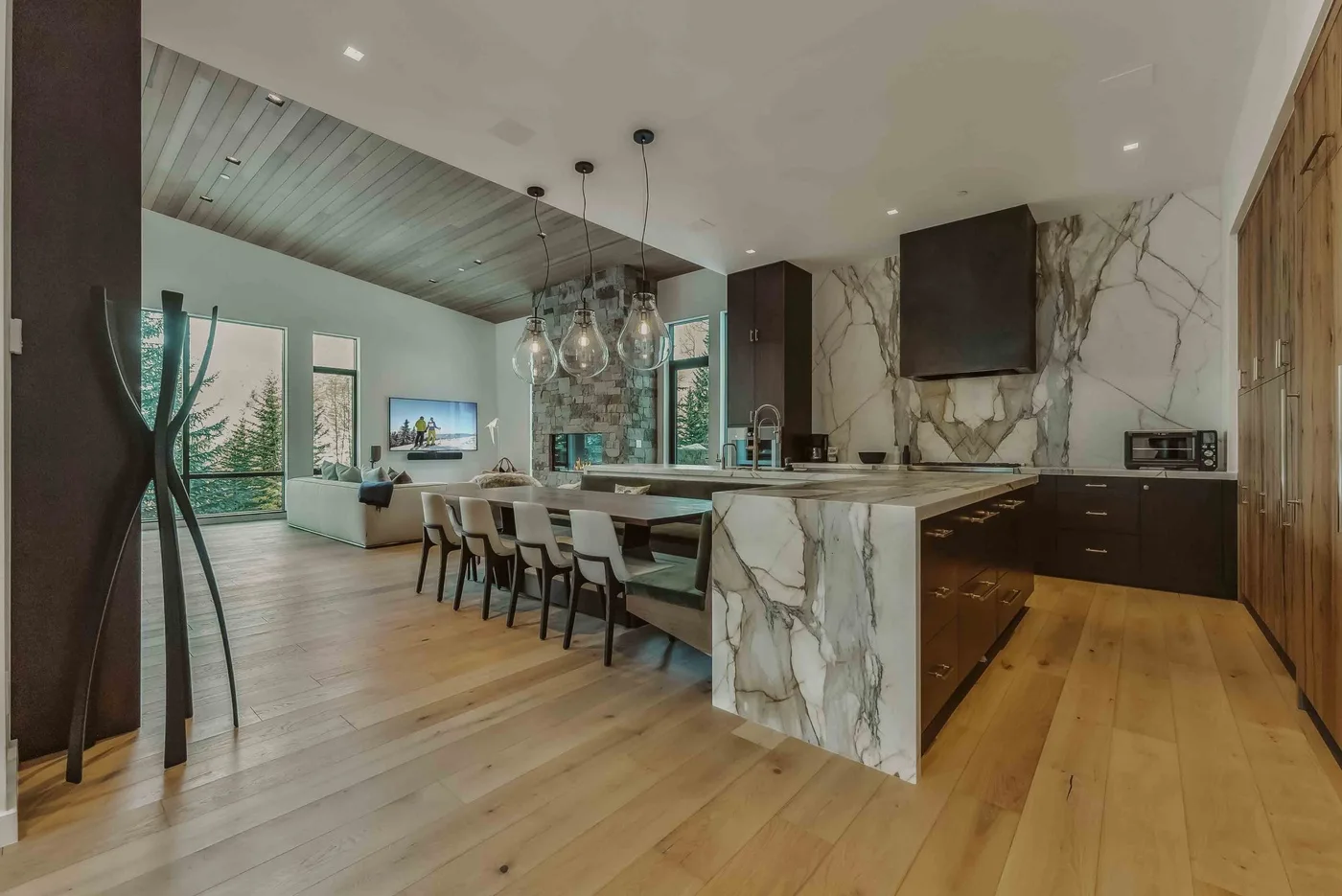 Cocina y comedor de concepto abierto con una isla larga y una mesa de comedor.