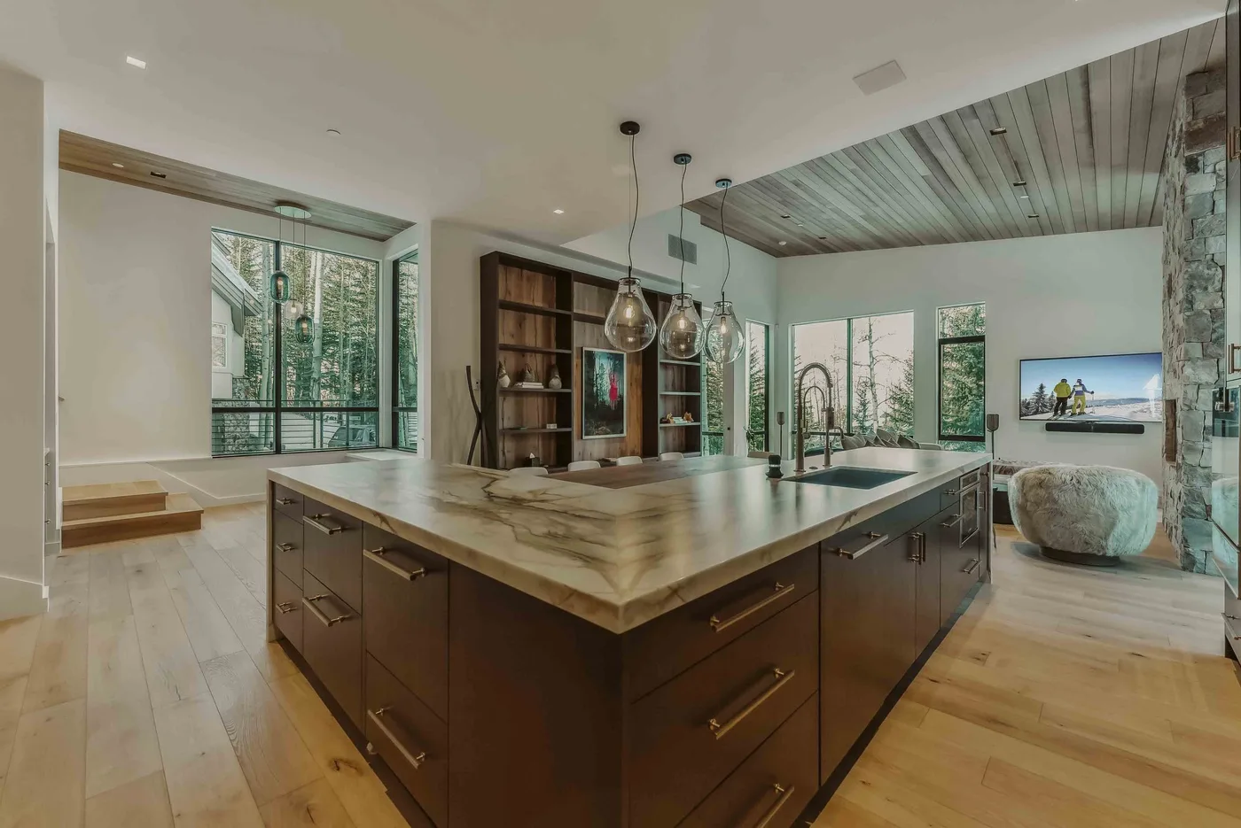 Una cocina moderna con una gran isla y lámparas colgantes.