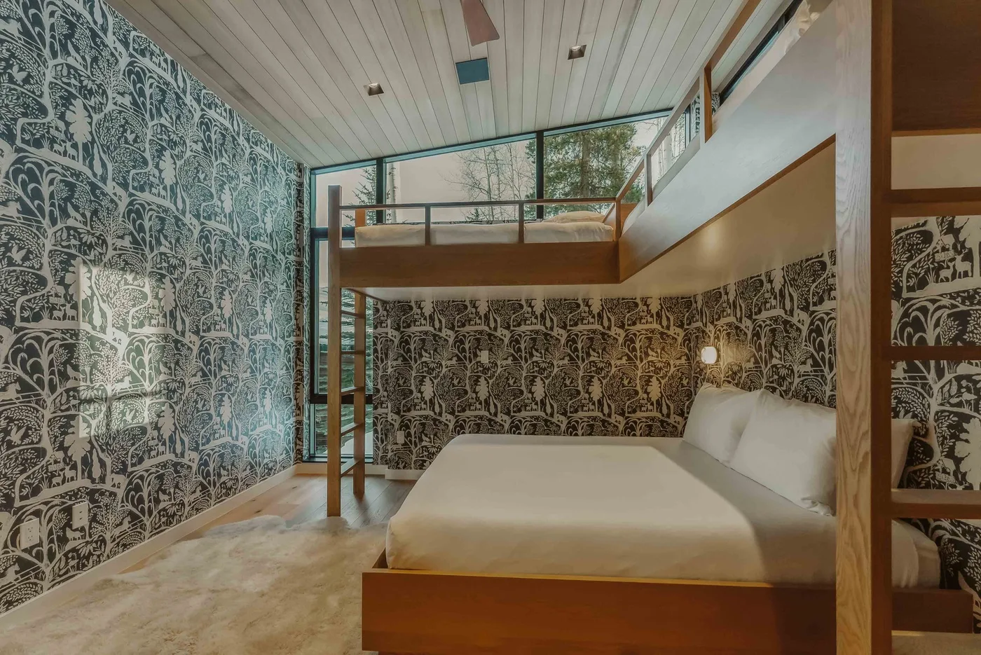Un dormitorio con una cama bajo un altillo y paredes estampadas.