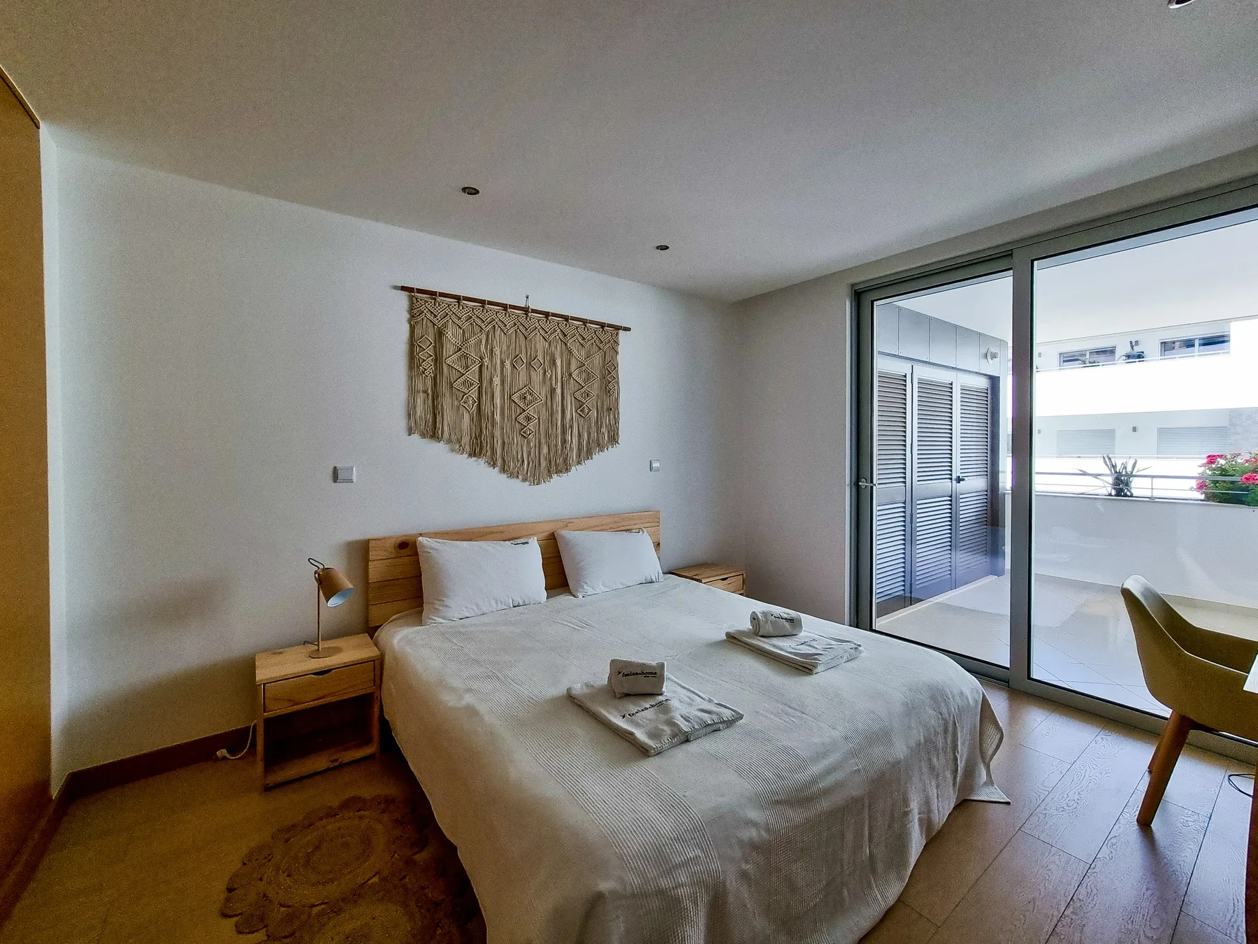 A bedroom with a bed and sliding glass doors opening onto a terrace.