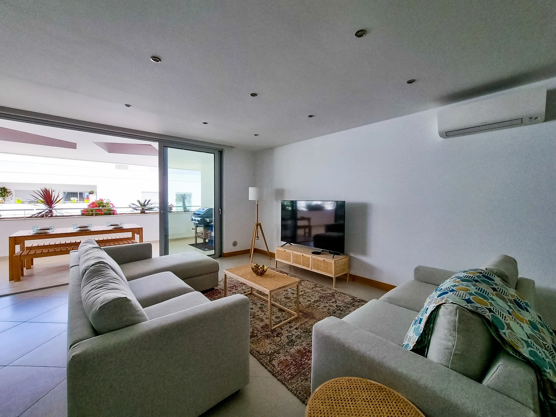 Living room with seating, a television, and sliding glass doors opening to a terrace.