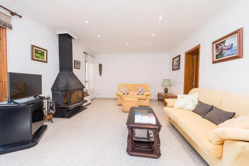 A bright living room with seating, a coffee table, and a fireplace.