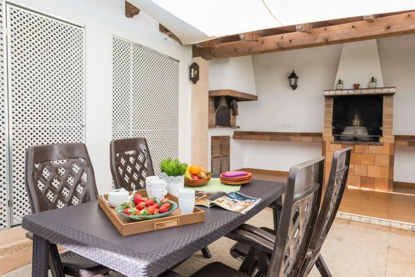 An outdoor dining area with a set table beside a built-in brick barbecue.
