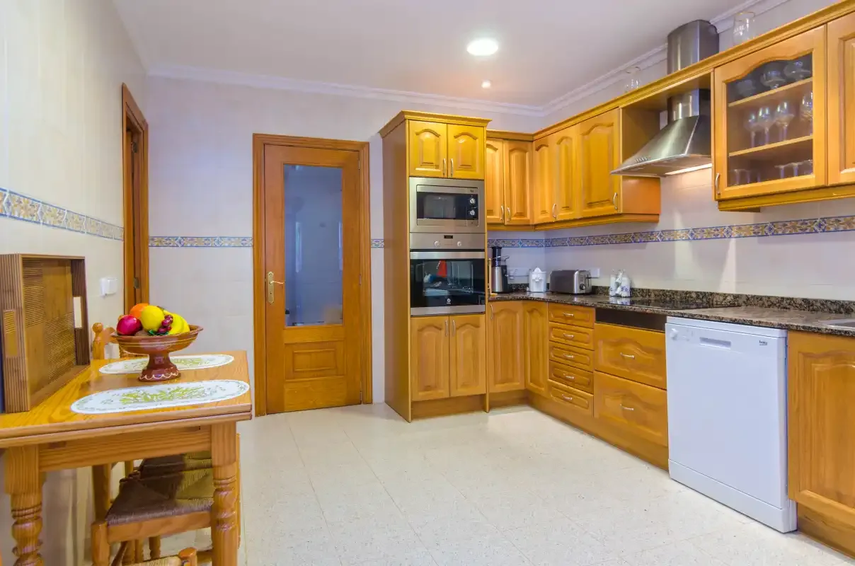 A kitchen with wooden cabinets, built-in appliances, and a countertop.