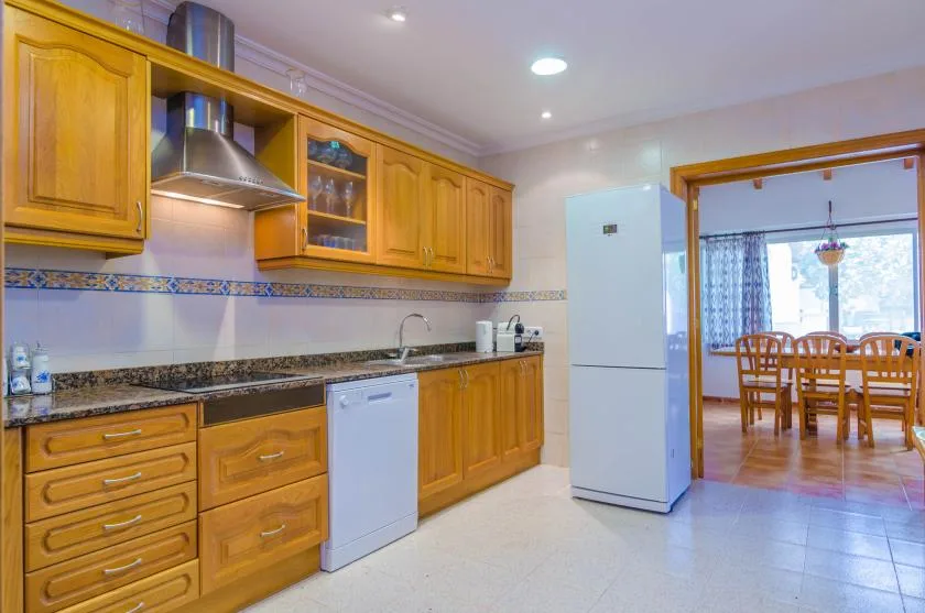A kitchen with wooden cabinets and a doorway leading to a dining area.